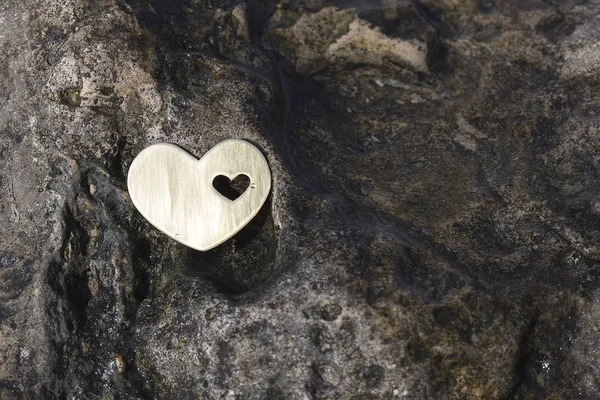 Сердце на темном мокром камне — стоковое фото