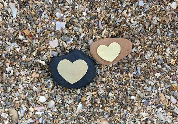 在沙滩上的黑色和红色的岩石上的两颗心 — 图库照片