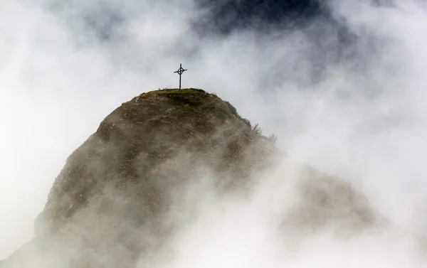 Risti vuorella pilvien kanssa — kuvapankkivalokuva