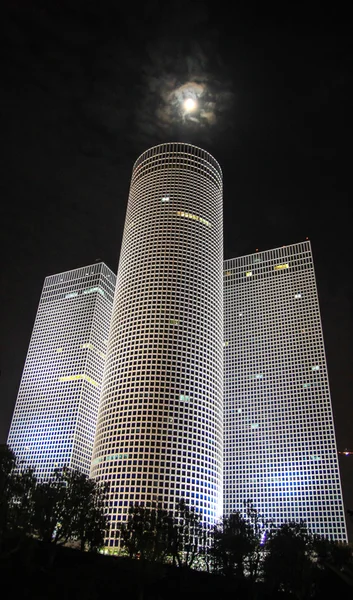 Azrieli står hög i Tel Aviv på natten med månen Stockbild