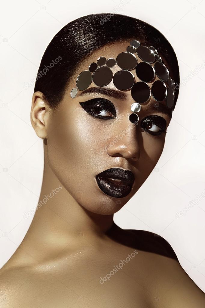 Negress. Mirror round ornament on her face. Ethnic beauty.