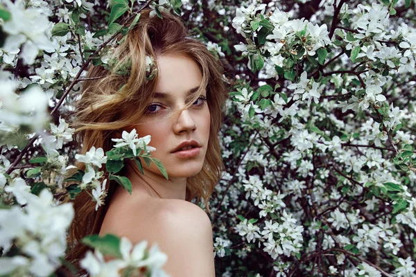 Chica de pie en flores blancas —  Fotos de Stock