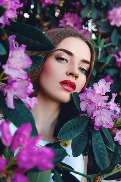 Mooi meisje in de struiken met grote bladeren — Stockfoto