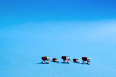 Mavi izole edilmiş arka planda çeşitli ilaçlar biblo biçiminde sergilenmektedir..