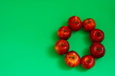 Yeşil arka planda parlak sulu kırmızı elmalar.