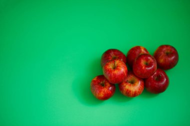 Yeşil arka planda parlak sulu kırmızı elmalar.