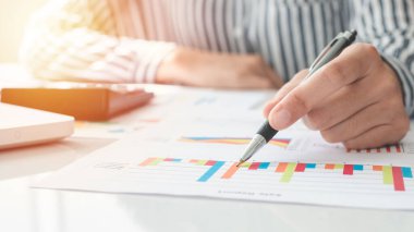 Business woman using calculator and writing make note with calculate. taxes and economic concepts. Savings, finances and economy concept through a laptop.