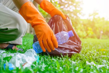 Çöpleri toplayan gönüllü bir adam. Çöp şişeleri toplandı. Plastik ve gıda atığı konsepti. Dünya gezegenini temizle, çöpleri topla, çevreyi kurtar, dünyayı kurtar..