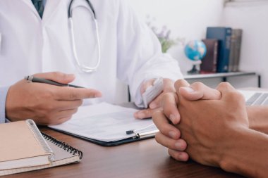Close up of patient and doctor taking notes. healtcare and assistance concept