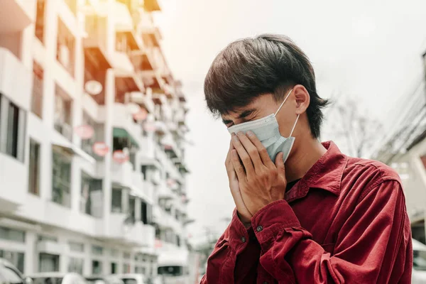 Man with medical face mask in the city. Air pollution, Concept of coronavirus quarantine. MERS-Cov, Novel coronavirus (2019-nCoV)