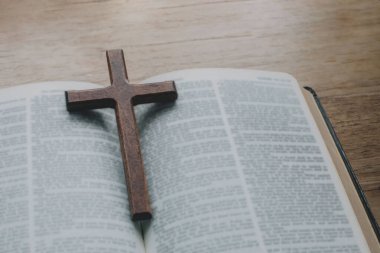 İncil 'in üzerindeki basit ahşap Hristiyan haç kolyesi. Umut, inanç, Hıristiyanlık, din, kilise kavramı çevrimiçi.
