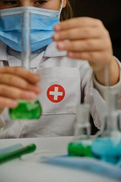 Ένα παιδί που παίζει το γιατρό με γυάλινη φιάλη και υγρά χρώματος. Εκπαιδευτικά και σχολικά πειράματα — Φωτογραφία Αρχείου