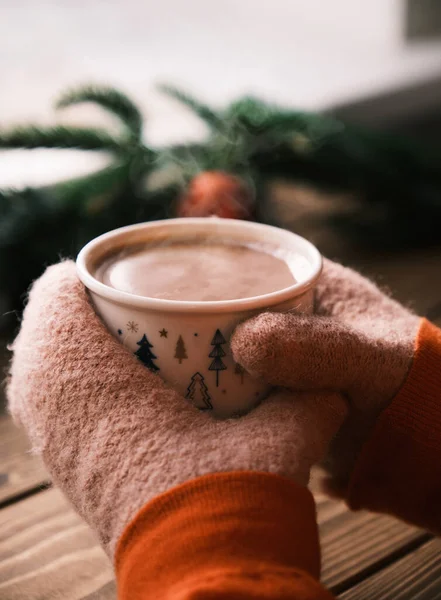 Manos de cerca en manoplas que sostienen la taza de chocolate caliente. Bebida caliente de Navidad —  Fotos de Stock