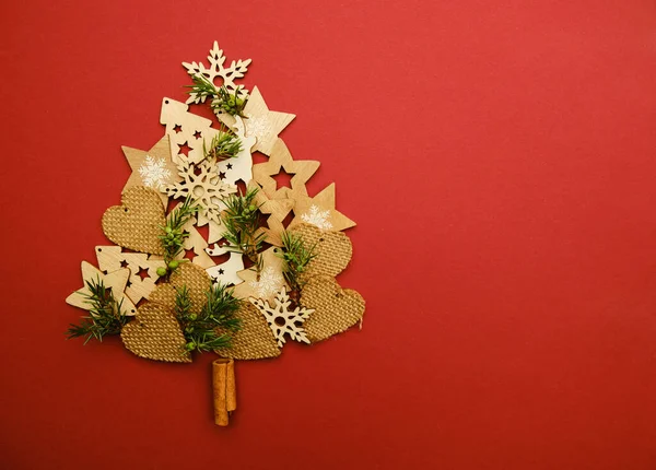 Árvore de Natal feita de corações de brinquedo e estrelas em um fundo vermelho vista superior — Fotografia de Stock
