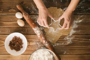 Tahtadaki çiğ hamurdan şekilli kurabiyeler. üst- görünüm