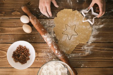 Tahtadaki çiğ hamurdan şekilli kurabiyeler. üst- görünüm