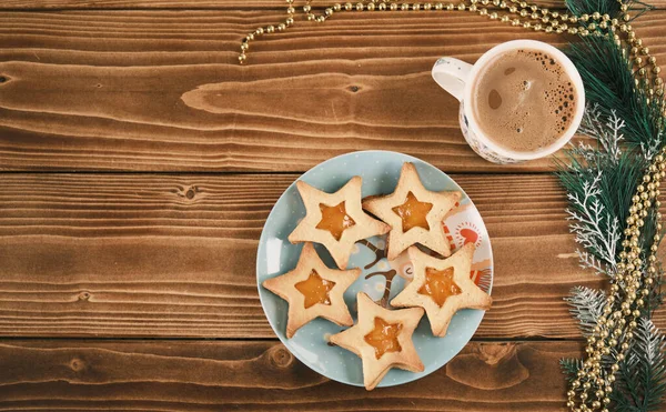 Galletas de jengibre en forma de estrella de año nuevo con una taza de café en la superficie de madera —  Fotos de Stock