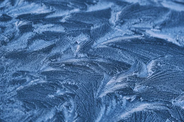 Dibujo de escarcha en el vidrio de la ventana, adorno de copo de nieve después de la anomalía helada. Vista superior azul — Foto de Stock