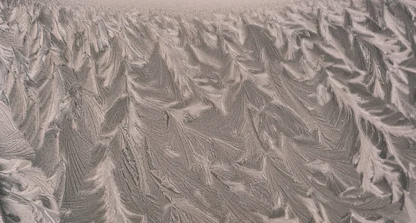 Dibujo de escarcha en el vidrio de la ventana, adorno de copo de nieve después de la anomalía helada. Vista superior azul —  Fotos de Stock