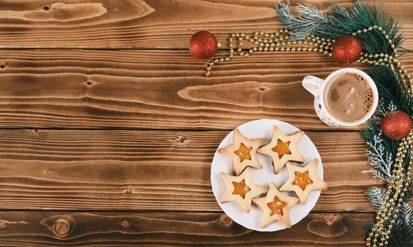 Galletas de jengibre en forma de estrella de año nuevo con una taza de café en la superficie de madera —  Fotos de Stock