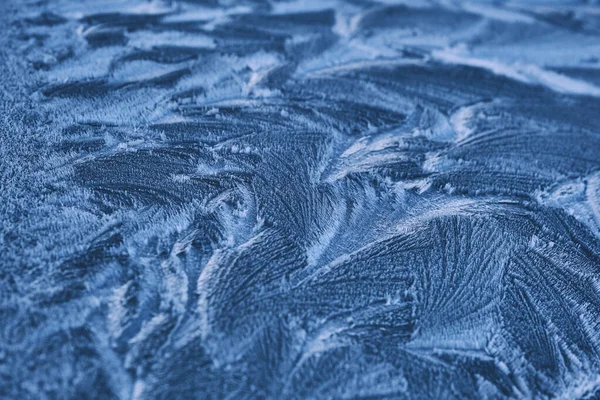 Frost menggambar di kaca jendela, ornamen kepingan salju setelah anomali es dingin. Tampilan atas biru — Stok Foto