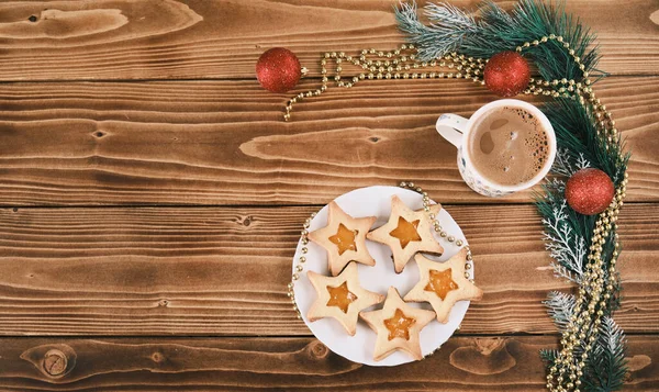 Galletas de jengibre en forma de estrella de año nuevo con una taza de café en la superficie de madera —  Fotos de Stock