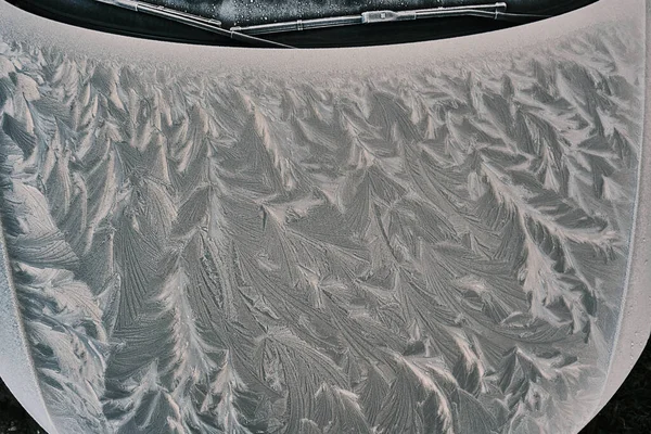 Primer plano de la campana congelada del coche durante la temporada de invierno. Capa de hielo —  Fotos de Stock