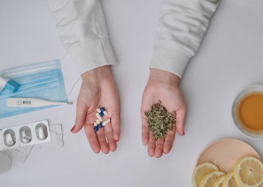 İlaç ya da şifalı ot konsepti. Doğal bitkiler. Ölçek olarak iki el. Salgın sorunu