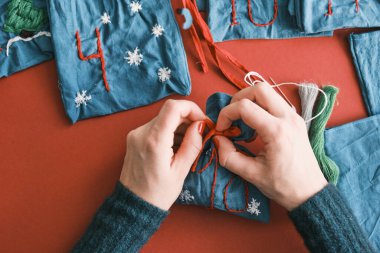 Noel hediyeleri için kumaş torbaları ve masanın üzerinde süslemeler olan el yapımı numaralar. Noel için el yapımı Advent takvimi