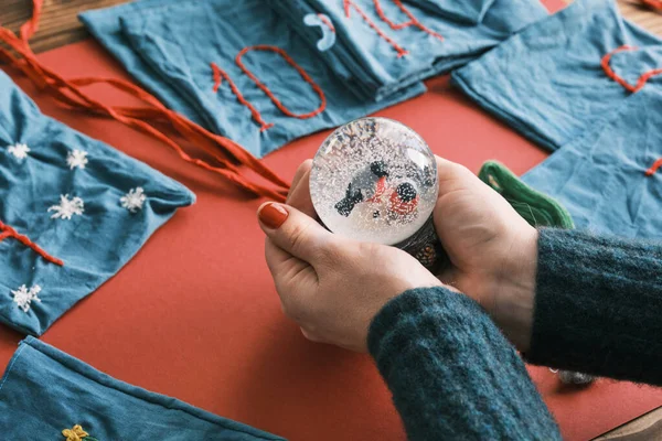 Снежный шар и Ткань сумки для рождественских подарков и ручной работы номера с украшениями на столе. Рождественский календарь ручной работы — стоковое фото