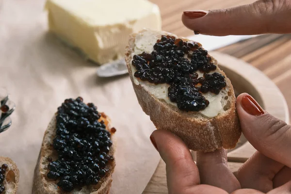 Sturgeon svart kaviar på en träskiva med smör Stockfoto