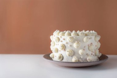 Turuncu arka planda beyaz pasta. Süslü kremalı pasta. Doğum günü pastası. Metin için yer