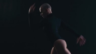 Kadın çevik dansçı siyah arka plan dansına karşı ve bir piruet yapıyor. Yüksek kalite 4K görüntü. Yavaş çekimde çalışıyor.