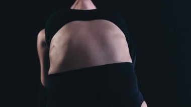 Siyah arka plan dansına karşı çevik bir kadın dansçı. Yüksek kaliteli FullHD görüntüler. Hareket eden bir ceset. 180 fps yavaş çekim.