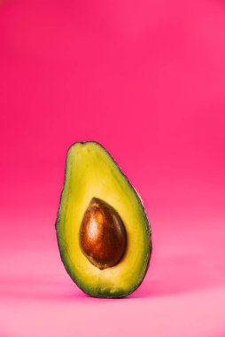 Renkli şeker. Tropik yaz geçmişi. Pembe arka planda yeşil avokado. Yemek konsepti. Asgari.