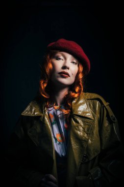 Yeşil trençkot ve kırmızı bereli klas kızıl saçlı kız. Retro Fransız tarzı. Kızıl saç..