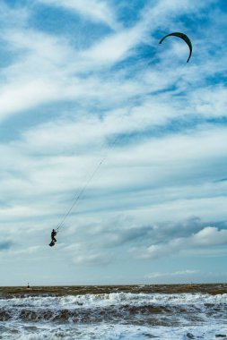 Kışın aşırı yüksek atlama ile fırtınada sörf yapan uçurtma. Scheveningen 'de Hollanda.