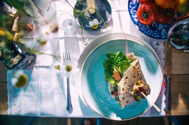 Süslü bir masada nefis güneşli bir İtalyan yemeğinin manzarası.