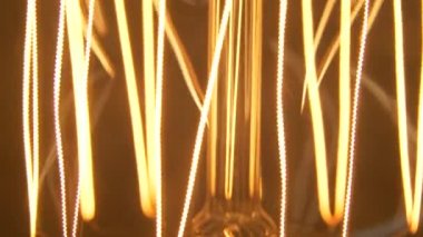 Filament ampulün makro yakın çekimi. Karbon filament ampul. Sanatsal teknoloji geçmişi. 4K çözünürlüğü.