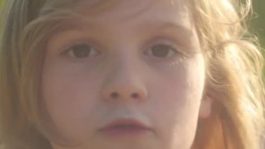 Yaz güneşinde mutlu bir kız. Özgün bir gülümseme. Yakın plan. Kaygısız