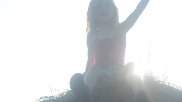 女孩坐在干草捆上享受无忧无虑的夏天 慢动作优质Fullhd影片 — 图库视频影像