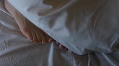 Yatakta birkaç sevişme. Çerçevede sadece ayak var. Evlilik, aile, aşk, seks konsepti. 4K 'da çekilmiş..