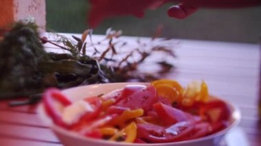 Yunan salatasına peynir koyuyorsun. Açık havada. Yaz. Yavaş çekim.