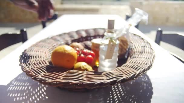 Καλάθι με δώρο καλωσορίσματος σε μια καλοκαιρινή βίλα με φρούτα και λαχανικά και ένα μπουκάλι ρακί. — Αρχείο Βίντεο