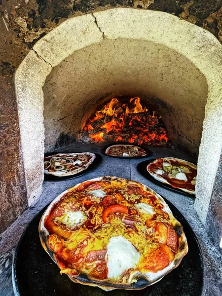 Pizza brick oven with pizzas.