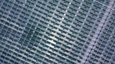 Büyük bir seranın üzerinde uçuyor. İHA atışı. Cama yansıyan gökyüzü görünümü.