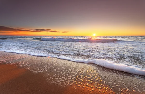 Colorido océano playa amanecer con cielo azul profundo y rayos de sol. —  Fotos de Stock