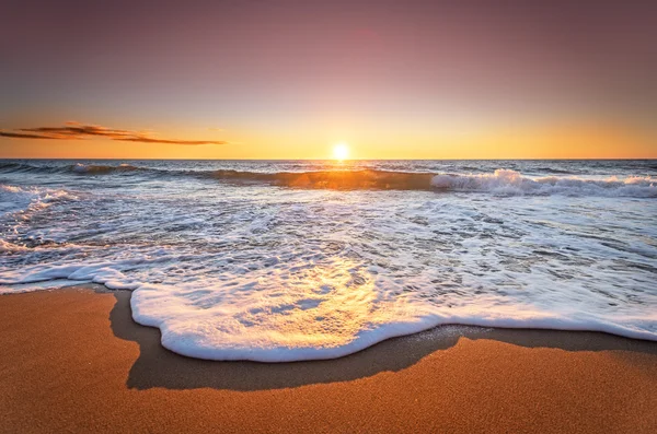 Bunte Meer Strand Sonnenaufgang mit tiefblauem Himmel und Sonnenstrahlen. — Stockfoto
