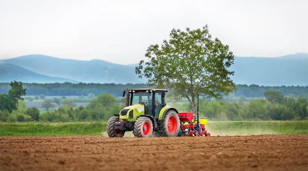 Traktor postřiku pole na jaře. — Stock fotografie