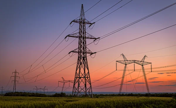 A villamos energia a tornyok naplemente alatt szép sziluett. — Stock Fotó